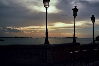 Scenic view of sea against cloudy sky at sunset