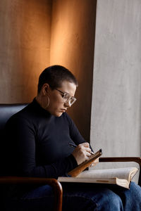 Young man using laptop while sitting on sofa at home