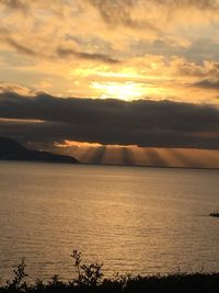 Scenic view of sea against dramatic sky during sunset