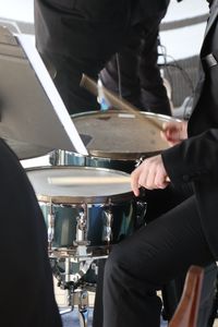 Midsection of man playing drums