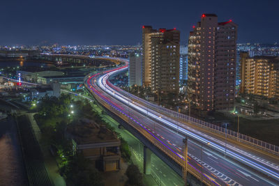 High angle view of illuminated street amidst buildings at night