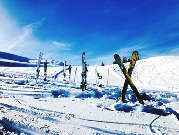 Ski on snow covered land against blue sky