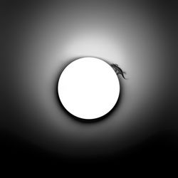 Low angle view of illuminated light bulb against black background