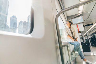 Rear view of woman standing in bus