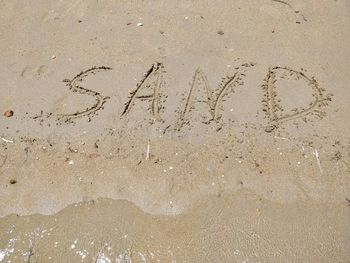 High angle view of text on sand at beach