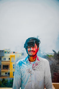 Portrait of young man standing against built structure
