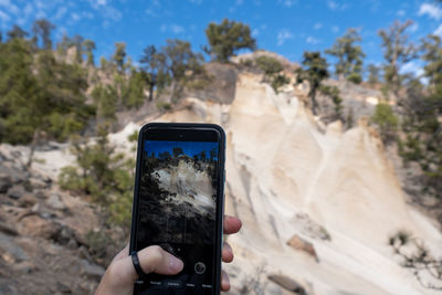 Close-up of person photographing the sandstone rocks of paisaje lunar with mobile phone