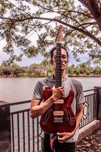 Man playing guitar on railing