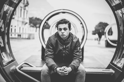 Young man sitting on sea at city street