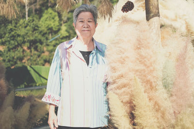 Portrait of smiling senior woman standing outdoors