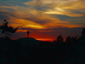 Scenic view of silhouette mountains against orange sky