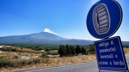 Road sign against clear blue sky