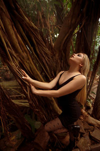 Young woman in tree trunk