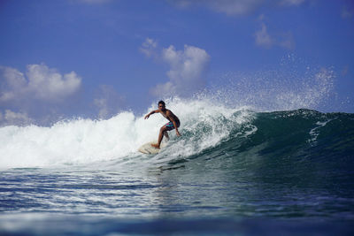 Man surfing in sea against sky