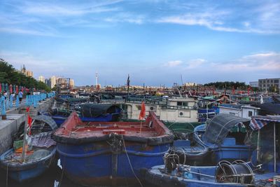 Boats moored at harbor against sky