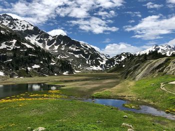 Scenic view of lake by mountains against sky