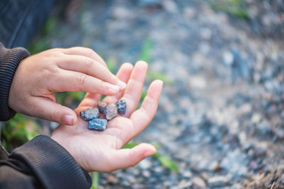 Cropped girl holding pebbles