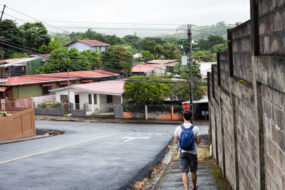 Rear view of man walking on street in city