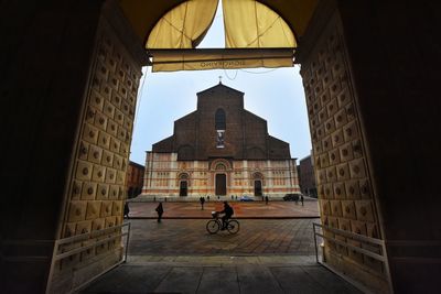 Low angle view of bicycle by historic building against sky