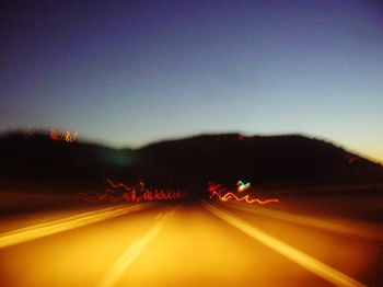 Road passing through illuminated tunnel