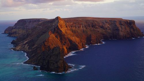 Rock formations by sea against sky