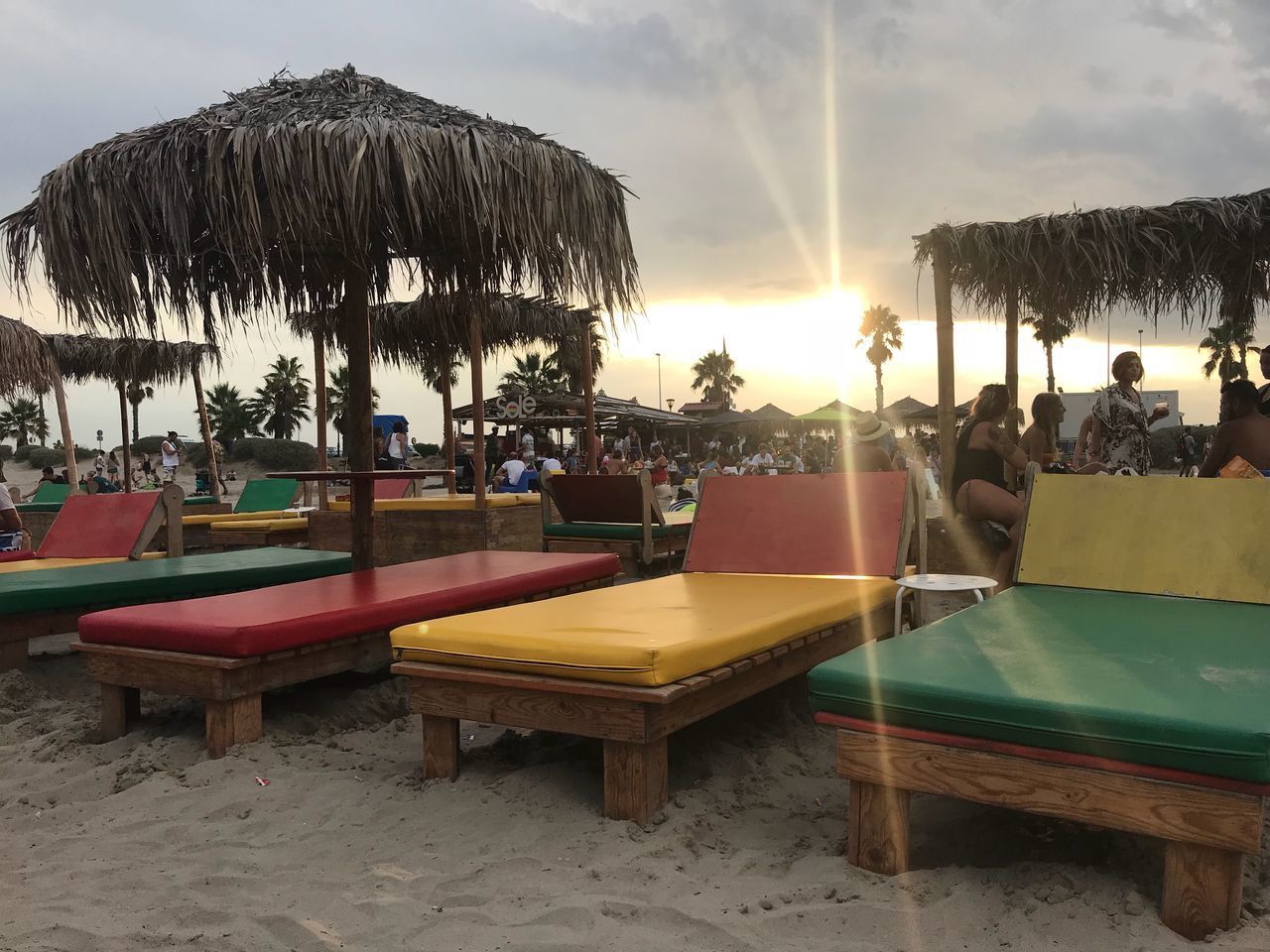 CHAIRS AND TABLES ON BEACH BY SEA AGAINST SKY