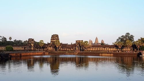 Reflection of temple in water against clear sky