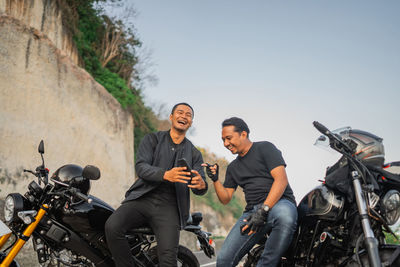 Low angle view of man riding motorcycle on road
