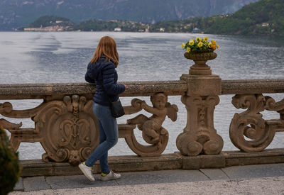 Rear view of woman standing by como lake