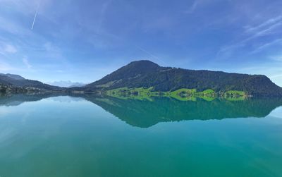 Scenic view of lake by mountain against sky