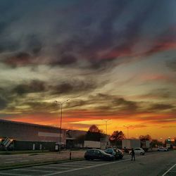 Parking lot against cloudy sky during sunset