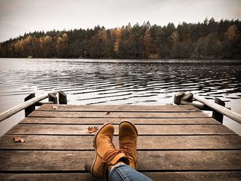 Low section of man on pier over lake