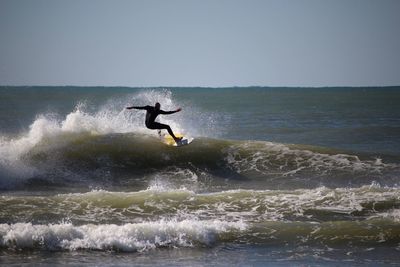 Rear view of man surfing on sea