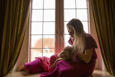 Woman looking at window at home