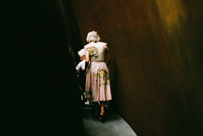 Rear view of two women walking in corridor