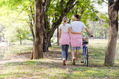 Rear view of couple walking along plants