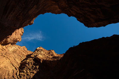 Low angle view of rock formations against blue sky