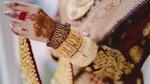 Cropped hand of woman holding gold handkerchief decorations