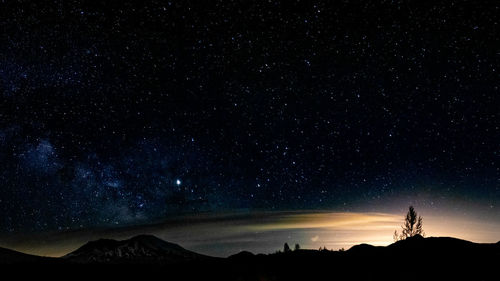 Scenic view of silhouette mountain against sky at night