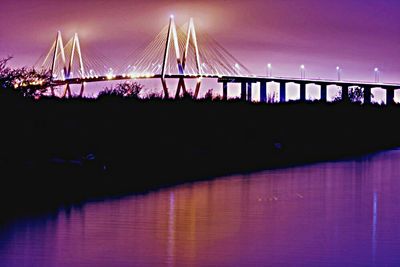 View of bridge over river at night