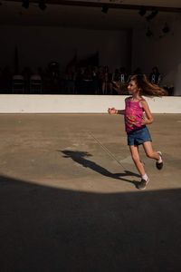 Full length of woman jumping on floor