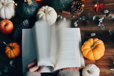 High angle view of pumpkins and book on table