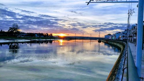 Bridge over river against sky during sunset