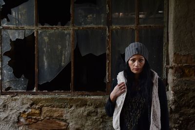 Woman standing against abandoned building