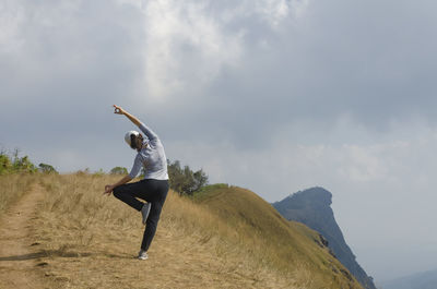 Full length of woman standing on mountain against sky