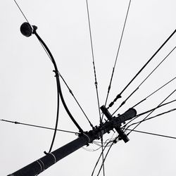 Low angle view of power lines against clear sky