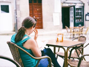 Rear view of woman sitting on bench