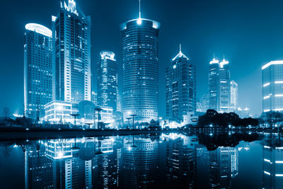 Illuminated buildings in city against sky at night