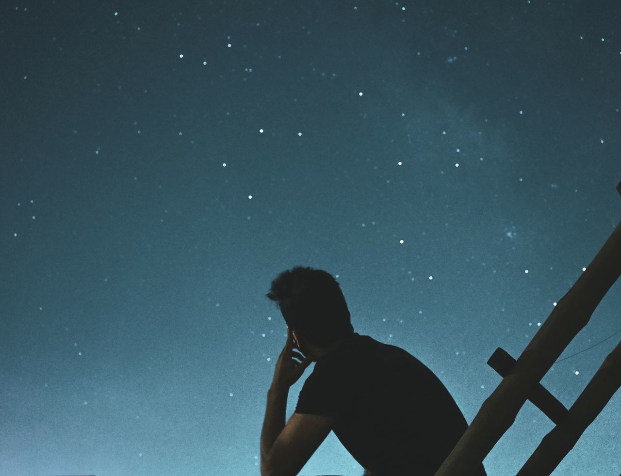 REAR VIEW OF SILHOUETTE MAN LOOKING AT STAR FIELD AGAINST SKY