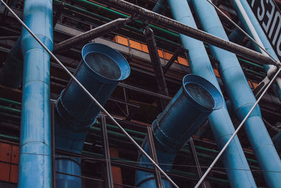 Low angle view of pipes against blue sky